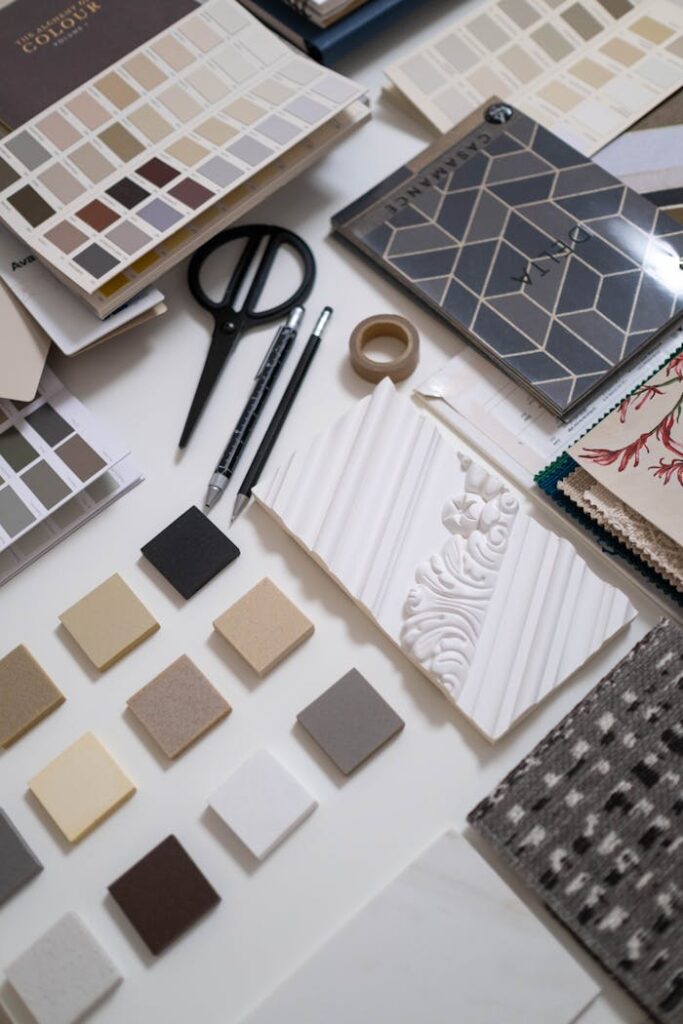 pexels-photo-6580007 A flat lay of a designer's workspace featuring color swatches and material samples for interior design.