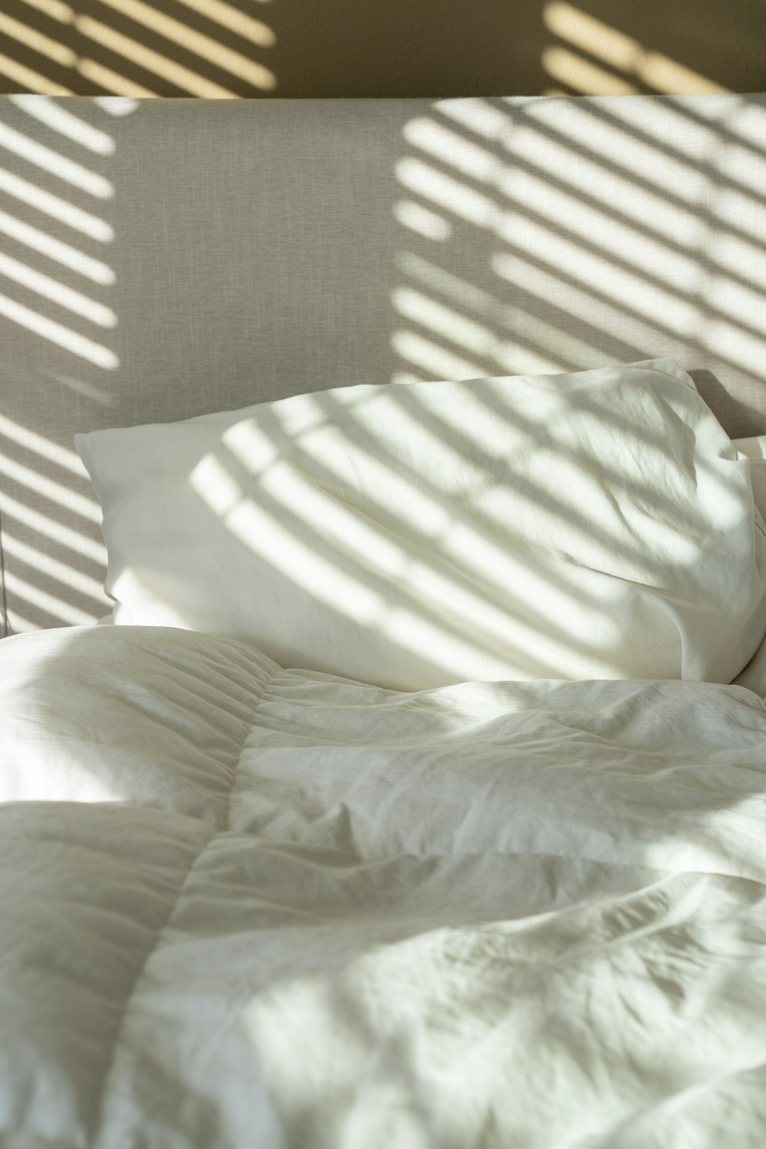 Bed met wit beddengoed en witte kussens