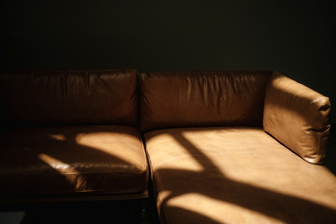 Bruine leren bank in het zonlicht