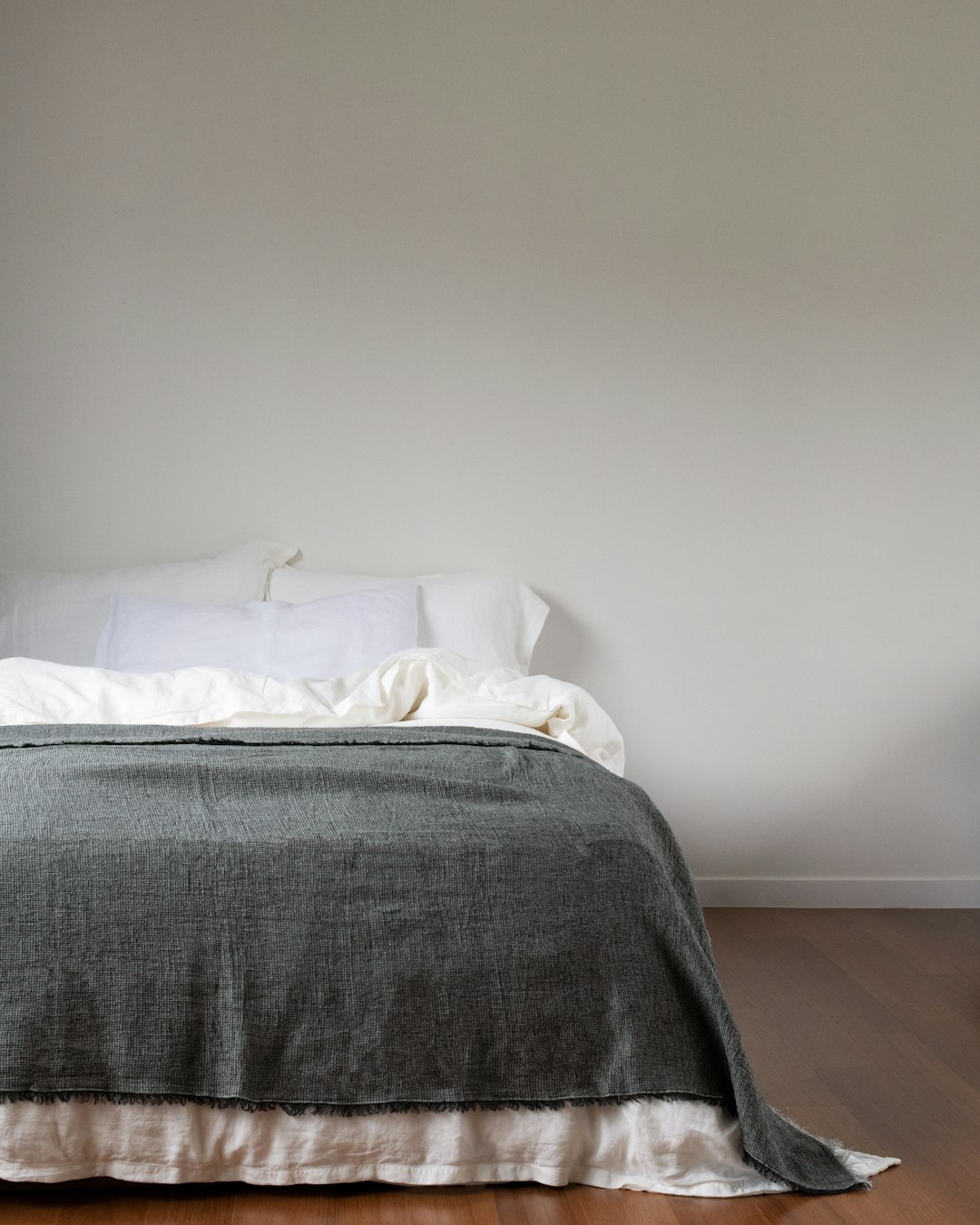 Opgemaakt bed met grijze plaid