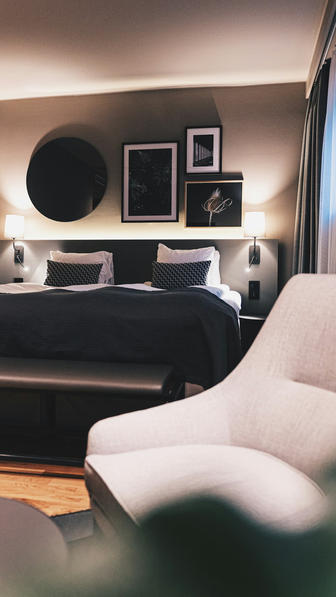 Witte fauteuil naast een zwarte bank in een hotelkamer